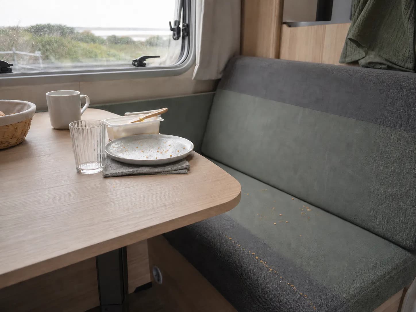 Liten handdammsugare vid matplatsen i en husvagn efter frukost